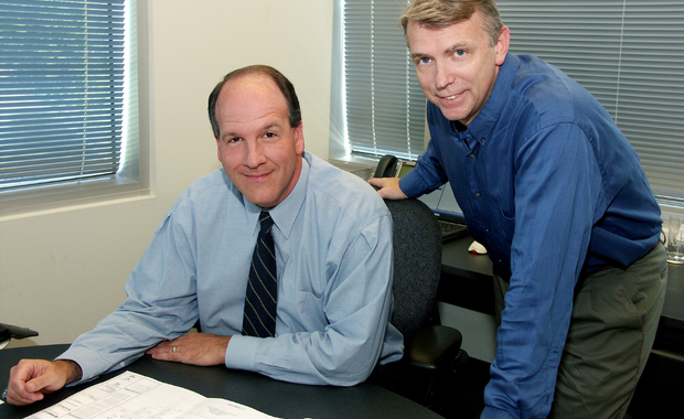 two businessmen smiling for the camera