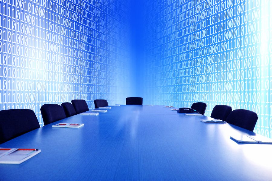 Meeting room with table and chairs. Binary code on walls in the background.