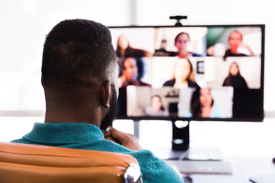 man looking at screen of people on Zoom