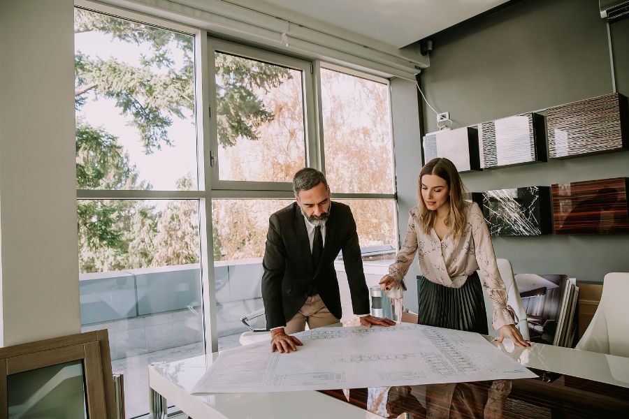 A man and a women looking at plans in an office.