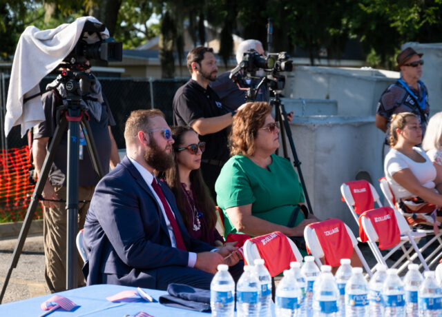 Audience seated at Aspire groundbreaking event with video cameras and crew in the background.