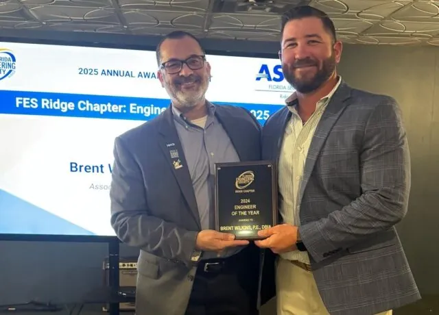 Brent Wilkins receiving Engineer of the Year award, smiling, at 2025 Annual Awards event