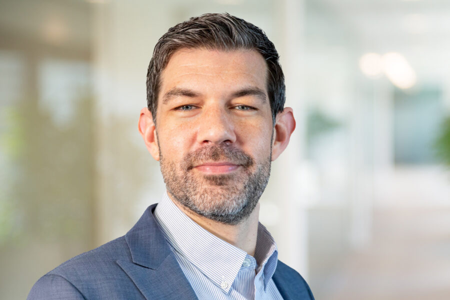 Furry David smiling in a bright office setting