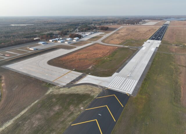 Aerial view of Alpena airport runway and surrounding landscapes, including taxiways, hangars, and open fields