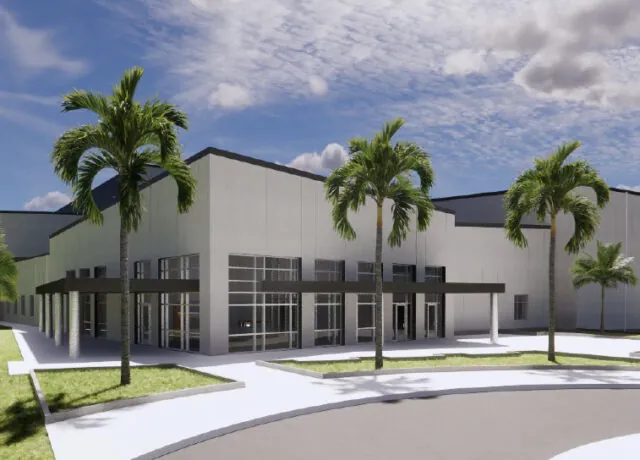 Modern building exterior with palm trees, clear skies, and large glass windows