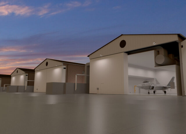 Aircraft hangars at dusk, with a jet partially visible inside one building