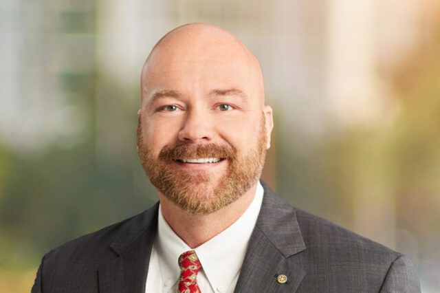 Timothy Parker smiling in a suit with a blurred background