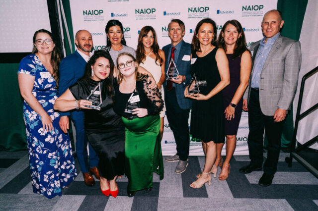 Group of people smiling and holding awards in front of NAIOP and Renasant logos