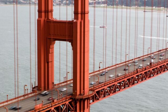 Golden Gate Bridge, cars driving on roadway, overcast sky
