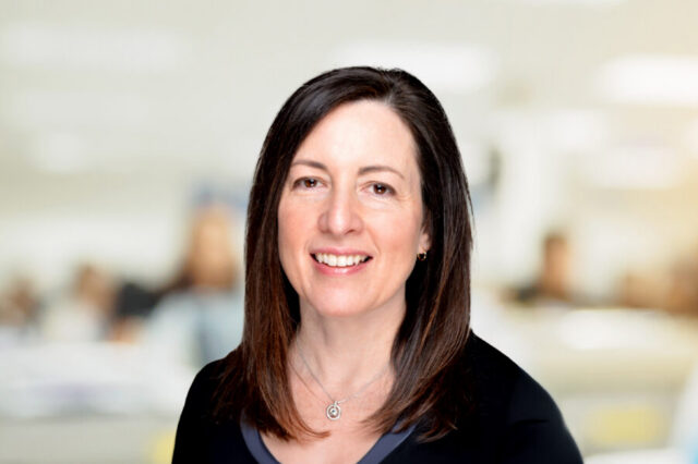 Janie Tiedeman smiling, with blurred office background