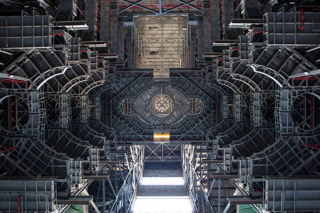 Interior view of NASA's Vehicle Assembly Building with intricate structural designs and high ceiling