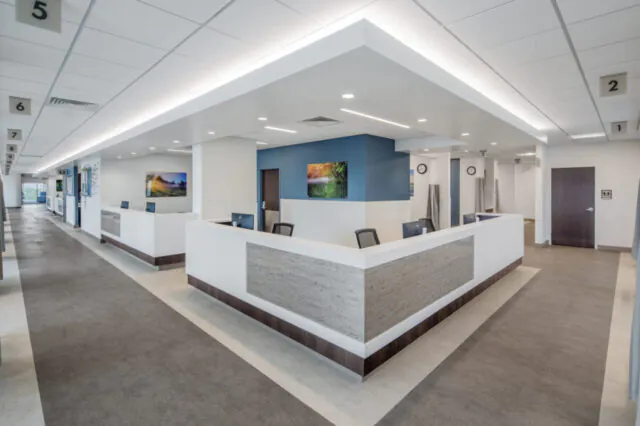 Modern medical facility reception area with numbered patient stations.