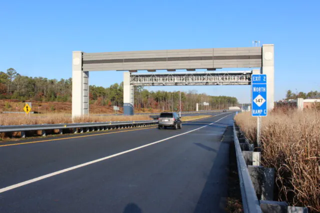 Car driving under highway gantry with Exit 2 North Ramp C sign