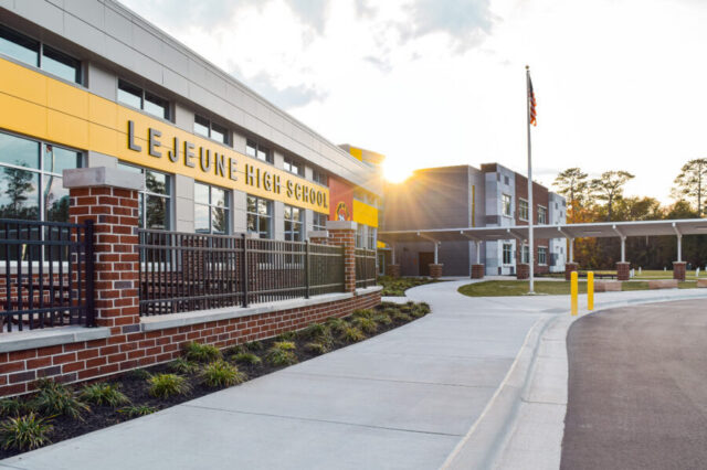 Lejeune High School exterior with sun setting, flagpole, and sidewalk