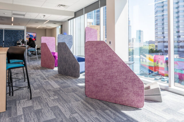 Modern office space with colorful partitions and city view.